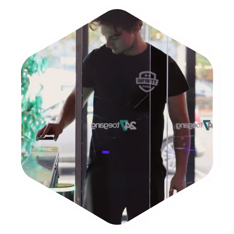 Man in black Infinity shirt standing at glass door with reflection
