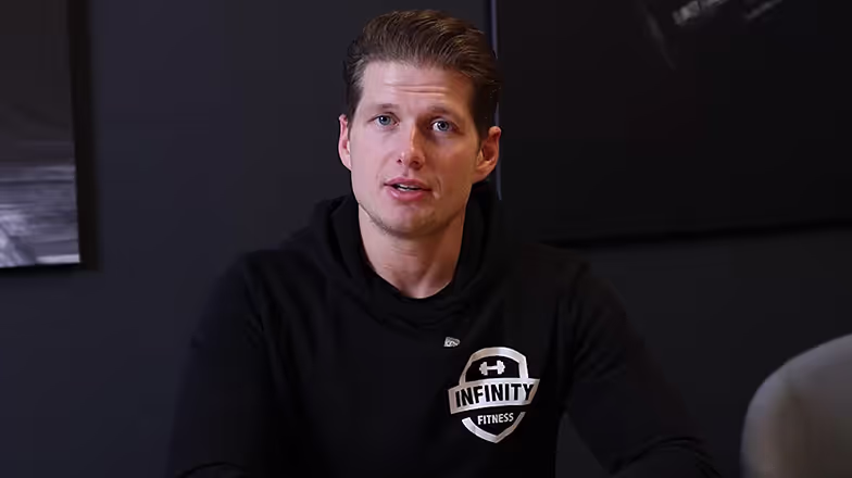 Instructor de fitness con camiseta negra con el logo de Infinity Fitness