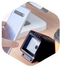 Hand holding modern barcode scanner above digital screen