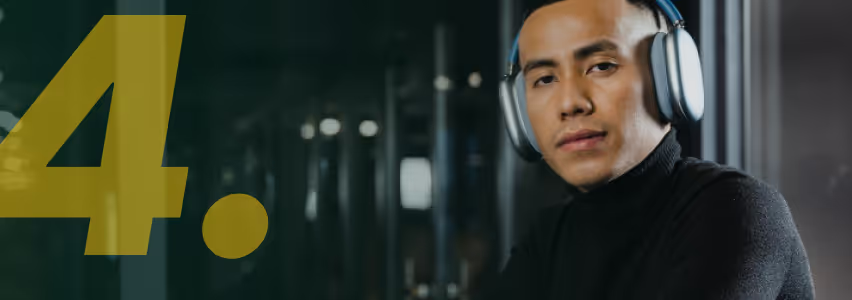 Hombre con auriculares escuchando música junto a un gran número cuatro amarillo