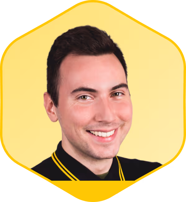 Profesional sonriente con camiseta negra sobre fondo hexagonal amarillo