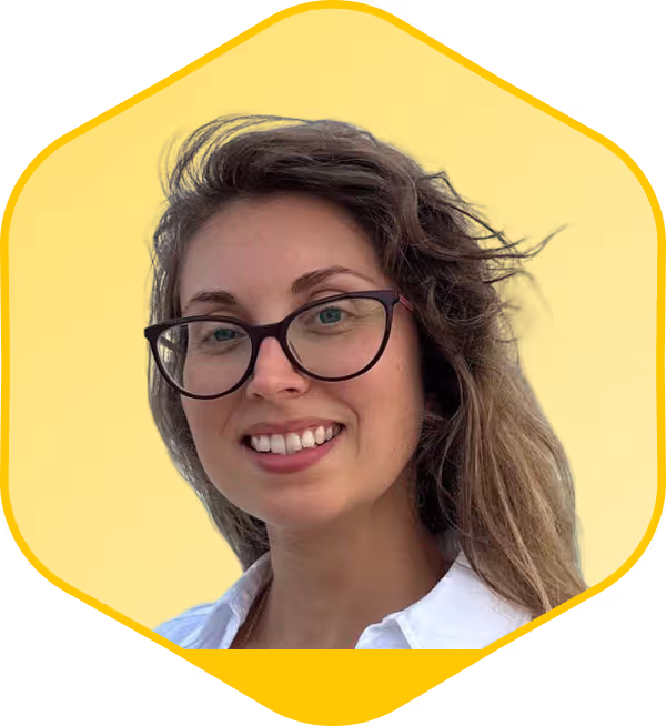 Mujer sonriente con gafas sobre fondo hexagonal amarillo